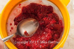 Pressing raspberries with a spoon
