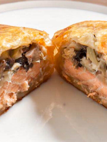 Salmon Wellington cut open to expose the filling on a plate