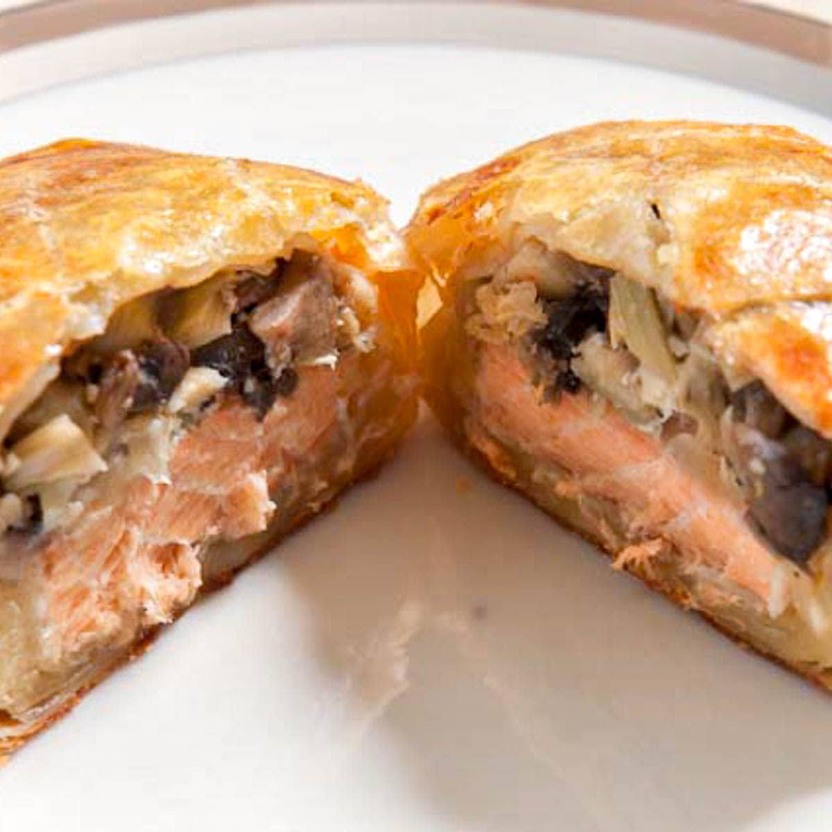 Salmon Wellington cut open to expose the filling on a plate
