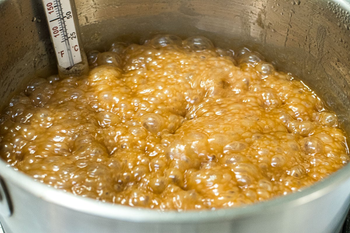 Caramel in the last stages of boiling.  It is a dark golden brown and it has risen quite high in the pot.