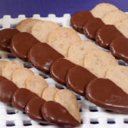 Toasted coconut and macadamia nuts are the basis of these heart shaped shorbreads on a lattice plate over purple.