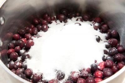 Cranberries ad sugar in pan