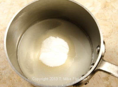 Water and sugar in pan
