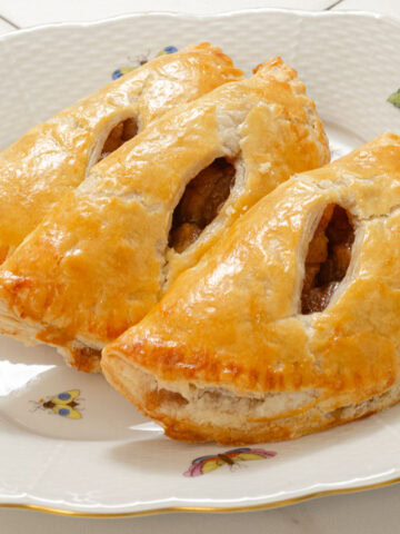 Three Apple Caramel Handpies on a white plate.