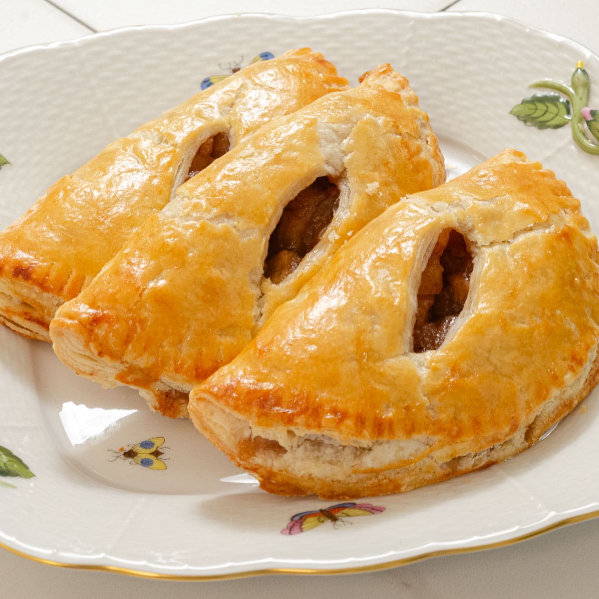 Three Apple Caramel Handpies on a white plate.