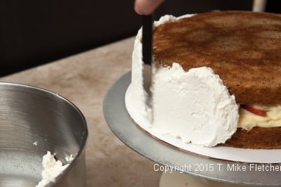 Spreading cream over side of cake