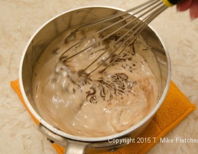 Whisking chocolate and cream for the Triple Chocolate Cheesecake