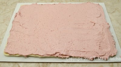 Raspberry buttercream spread on first layer