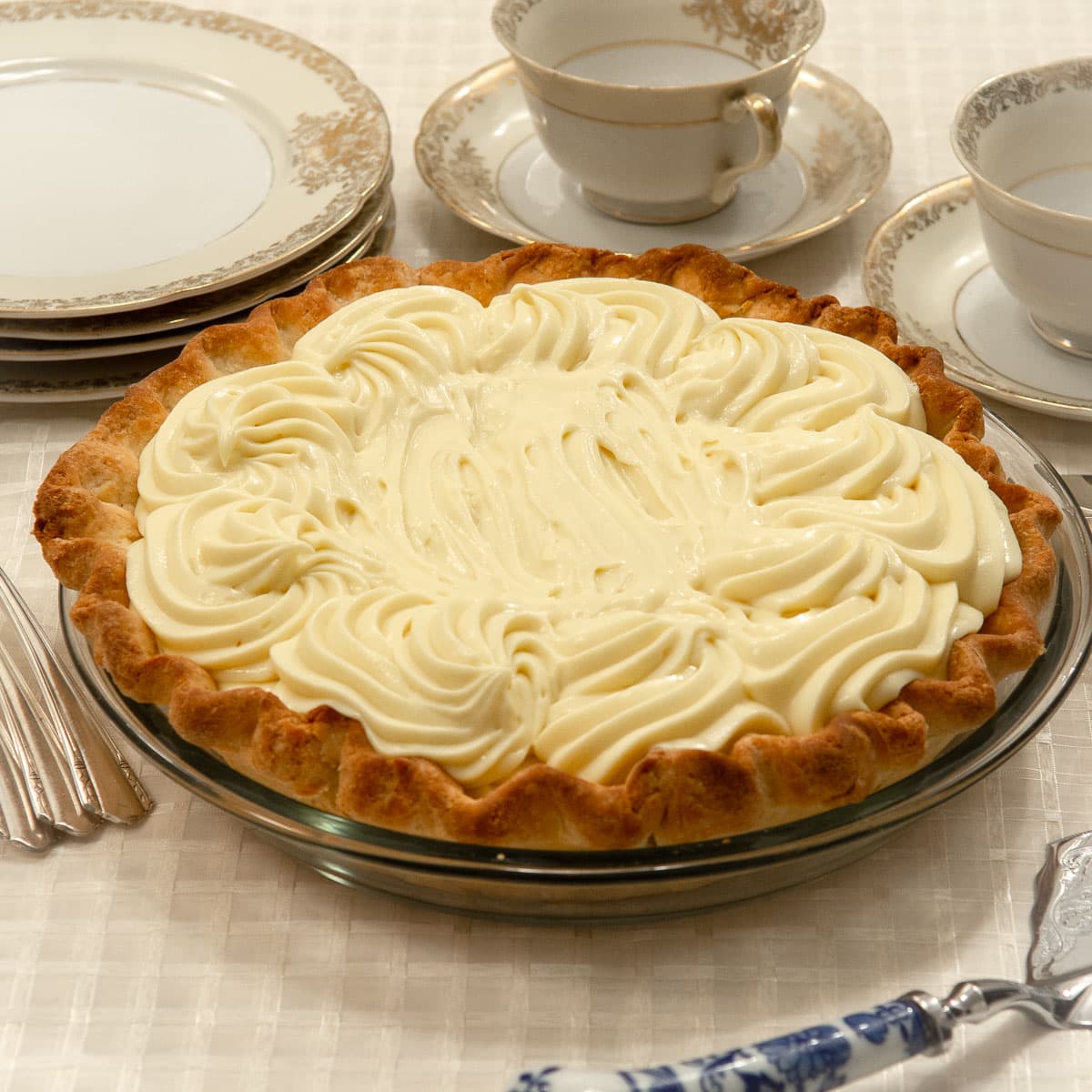 Double Banana Cream Pie with plates and cups and saucers.
