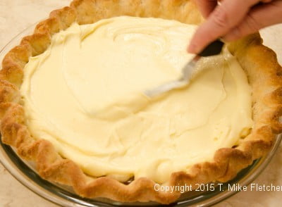 Spreading pastry cream over bananas for Double Banana Caramel Cream Pie