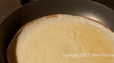 Edge of crepe browned indicating it is ready to turn over at The All Purpose French Crepes