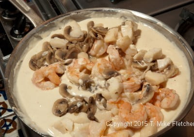 Seafood and mushrooms added to béchamel sauce for Seafood Crepes