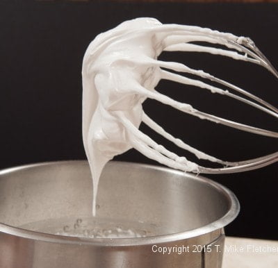 Whipped marshmallow on a whisk for Hazelnut Crunch Bar