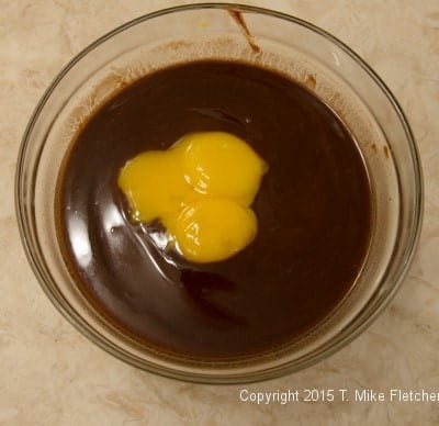 Egg yolks being added to chocolate mousse for the Double Chocolate Mousse Cake