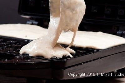 Pouring batter into waffle iron for Belgium Waffles