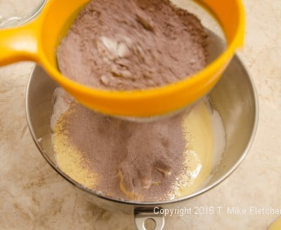 Sifting half the dry ingredients over the egg mixture for the Buche de Noel