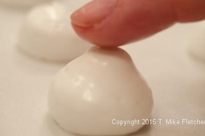 Smoothing the point on a meringue mushroom for the Buche de Noel