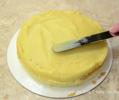 Pastry cream spread on bottom layer for the Boston Cream Pie