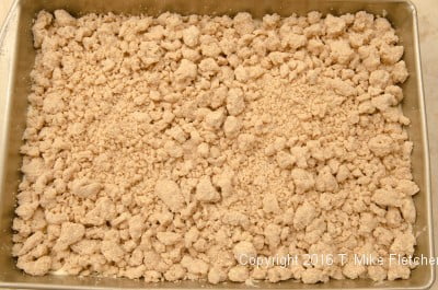 Crumbs spread on batter for the New York Crumb Cake