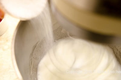 Adding sugar to egg whites for the Lemon Raspberry Pudding Cake