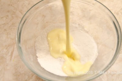 Liquid ingredients into dry for the lemon Raspberry Pudding Cake