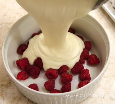 Pouring batter over the raspberries for Lemon Raspberry Pudding Cake