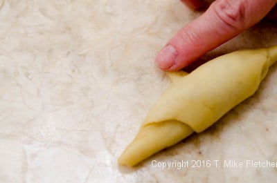 Dampen the tip of the dough for the Kifle with Walnut Filling