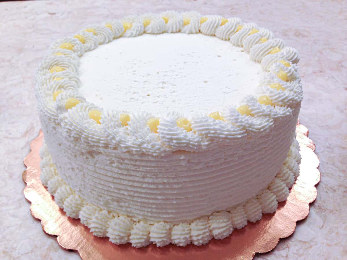 A whipped cream finished Blueberry Lemon Cake