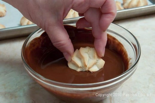 Dipping Almond Macaroons halfway.