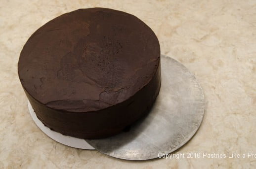 Cake being transferred to a metal round for the Chocolate Strawberry Ruffle Cake