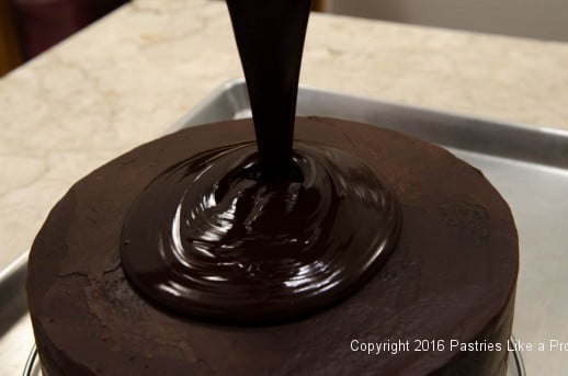 Pouring ganache on top of the cake for the Chocolate Strawberry Ruffle Cake