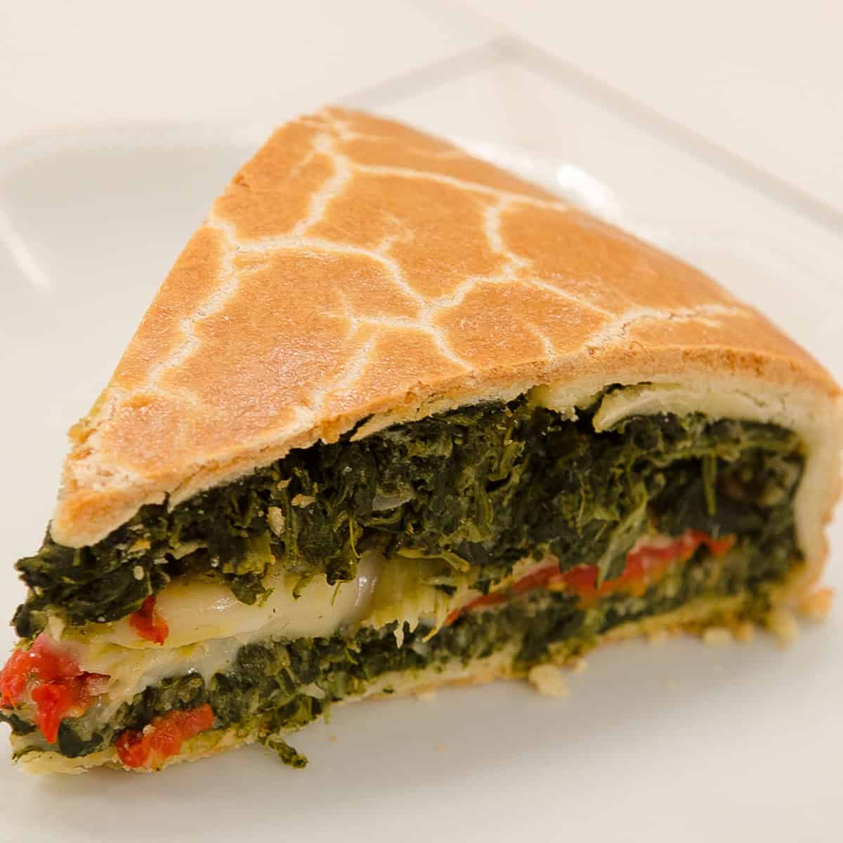 A slice of the Torta Rustica sits on a cream colored plate.