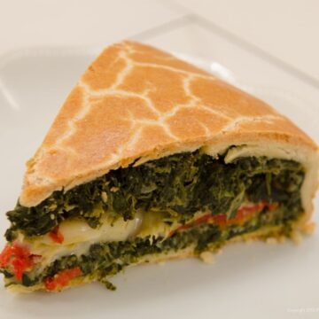 A slice of the Torta Rustica displaying the multiple layers of the filling.