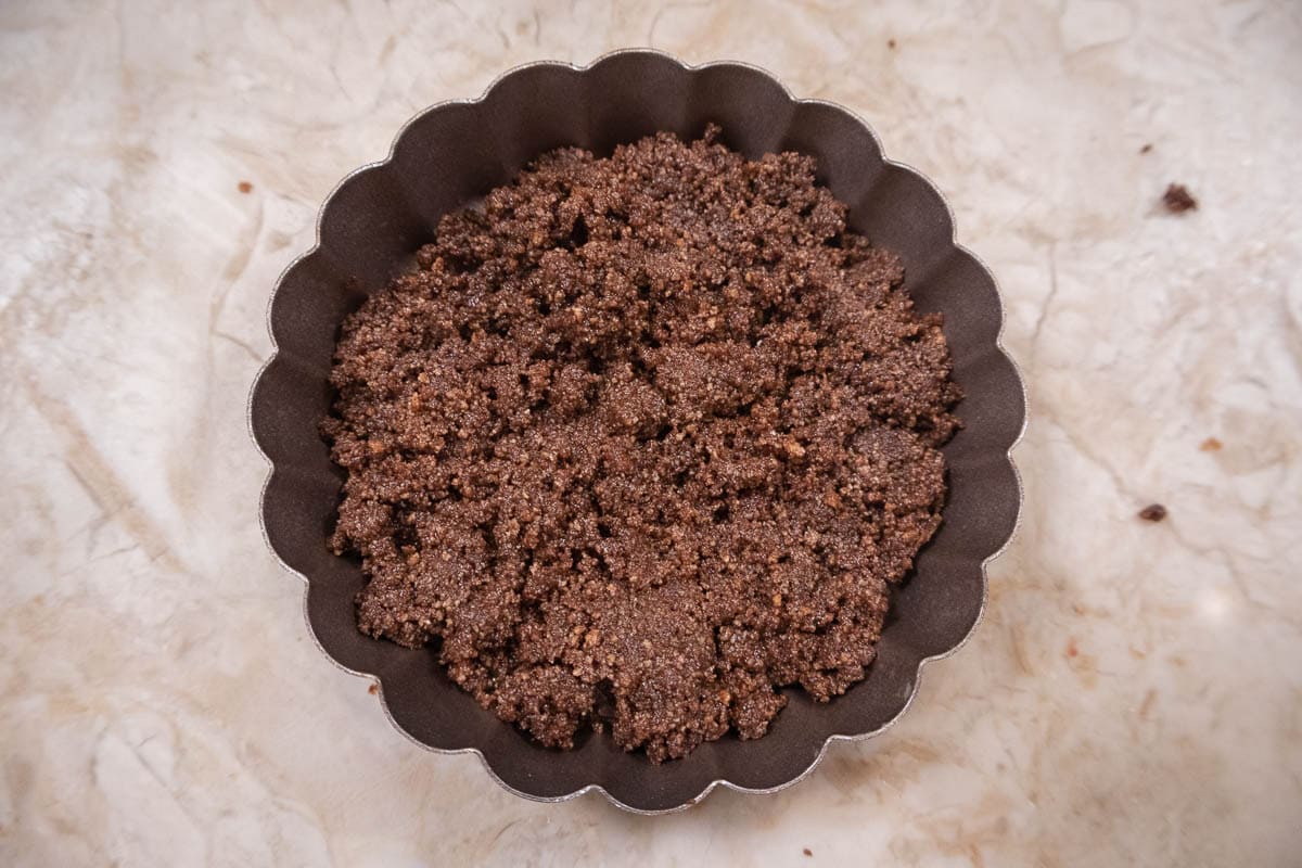 ⅔ of the crumbs are placed in the bottom of the tart pan.