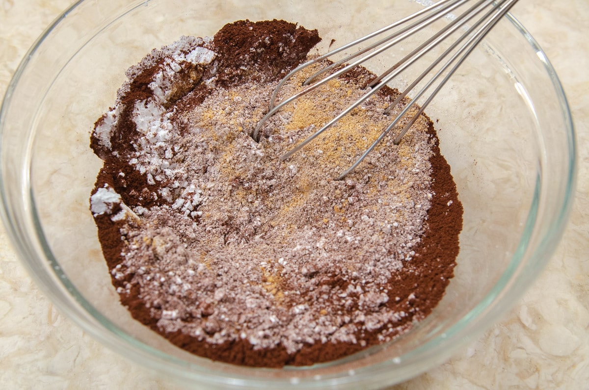 The graham cracker crumbs, powdered sugar and cocoa are being whisked together in the bowl.