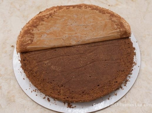 Removing paper on cake layer for the Chocolate Raspberry Marzipan Gateau