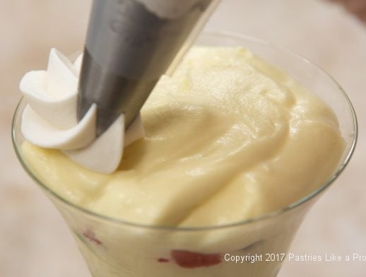 Piping the whipped cream for the Strawberry Chocolate Crunch Parfait