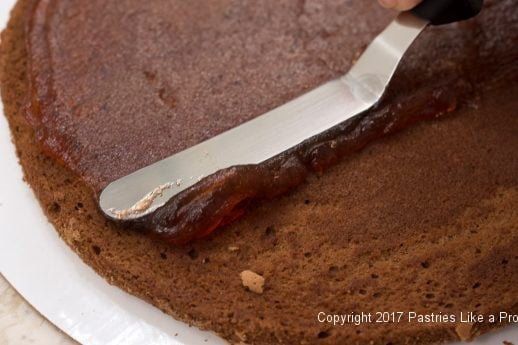 Raspberry jam being spread for the Chocolate Raspberry Marzipan Gateau