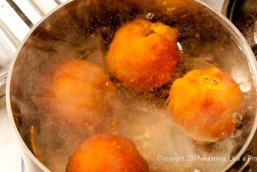 Peaches boiling for the White Wine Amaretto Peach Sauce