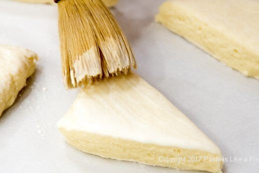 Brushing with cream for Scones with Cranberry Strawberry Jam