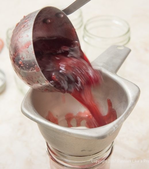 Ladeling jam into jars for Scones with Cranberry and Strawberry Jam