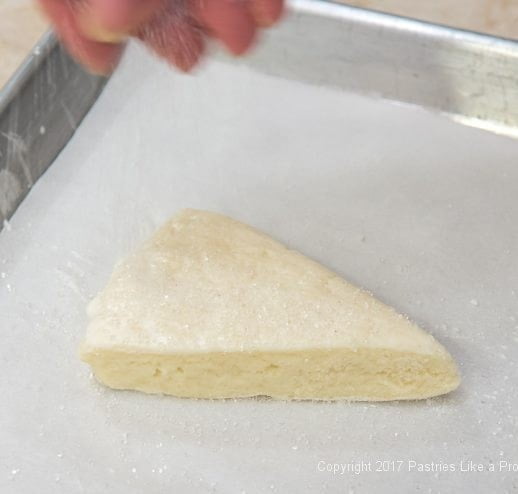 Sprinkling scone with sugar for Scones with cRanberry and Strawberry Jam