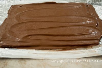 Chocolate spread over toffee for Salted Macadamia Rum Toffee, Rum Toffee Recipe