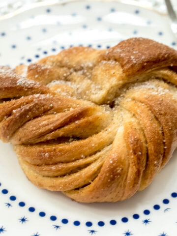 A Swedish Cardamom Knot sits on a blue and white plate