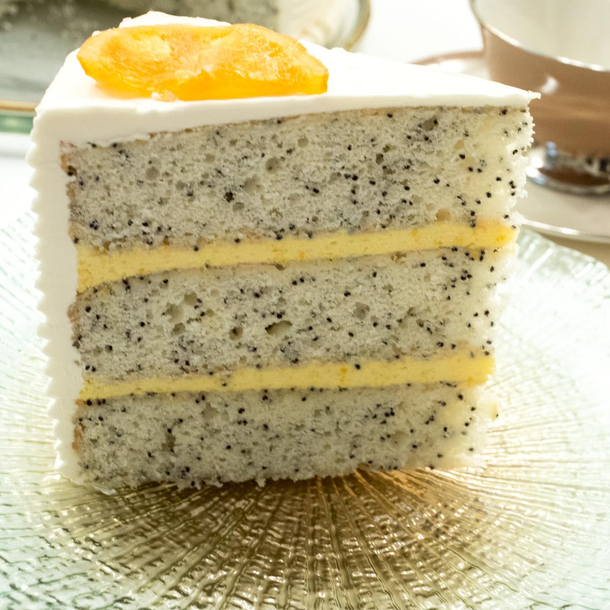 A sour cream cake laden with poppyseeds filled with orange curd and finished white chocolate buttercream