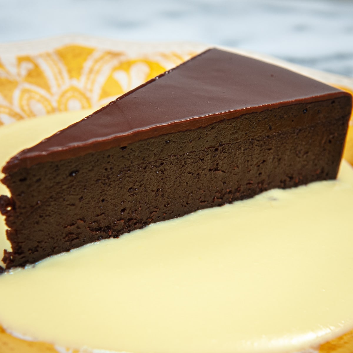 This Ultimate Chocolate Fudge cake is gluten free and easy to make. It is finished with a chocolate glaze and served with a Vanilla Creme Anglaise