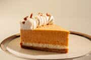 A singles slice of the torte sits on a cream colored plate rimmed in beige and sliver.