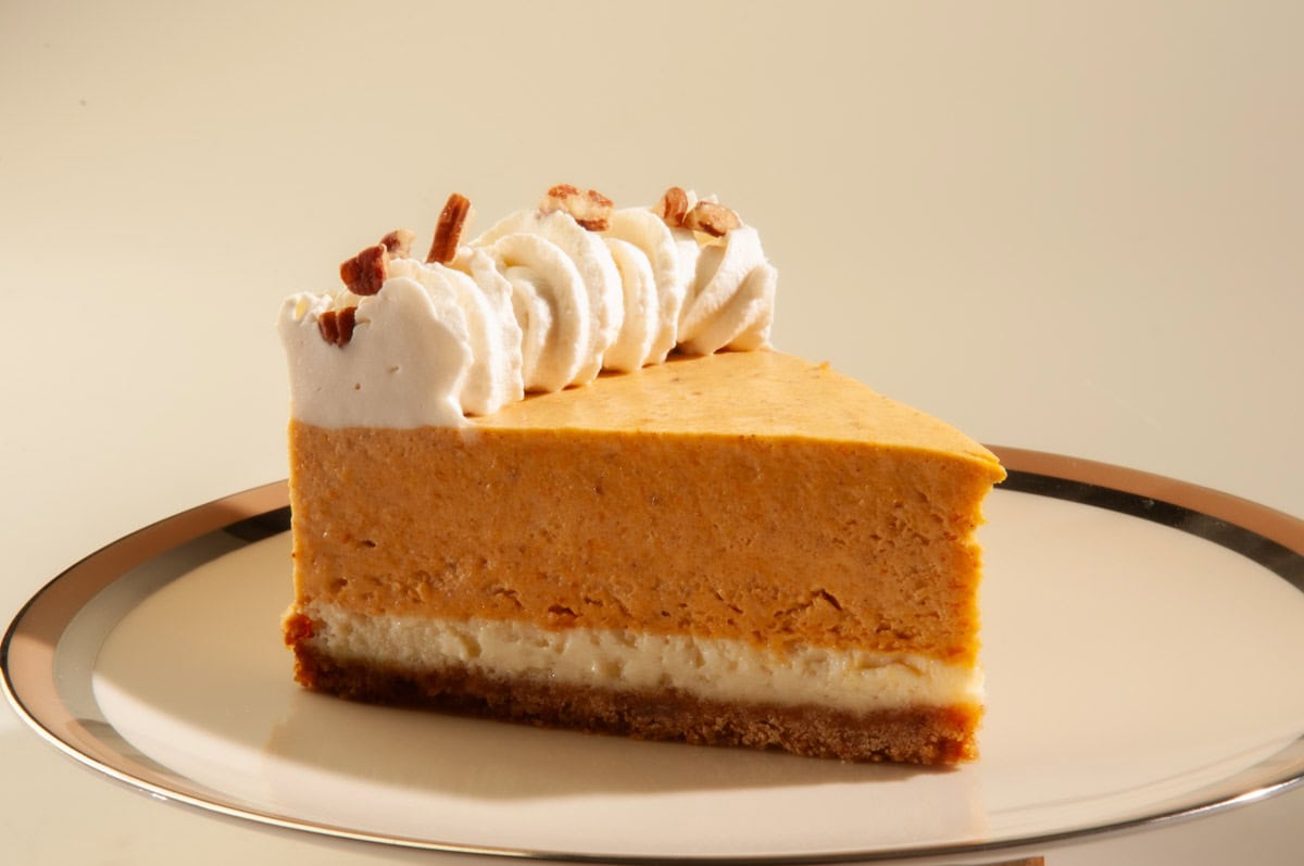 A singles slice of the torte sits on a cream colored plate rimmed in beige and sliver. 
