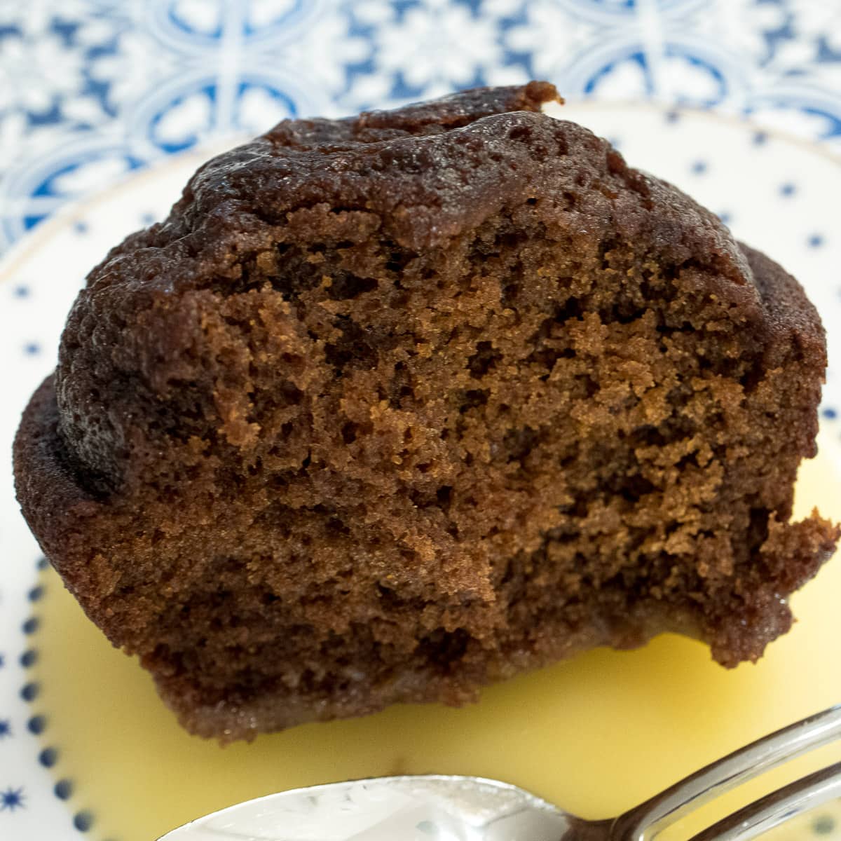 An individual Gingerbread with Orange Sauce on a white plate with dots.