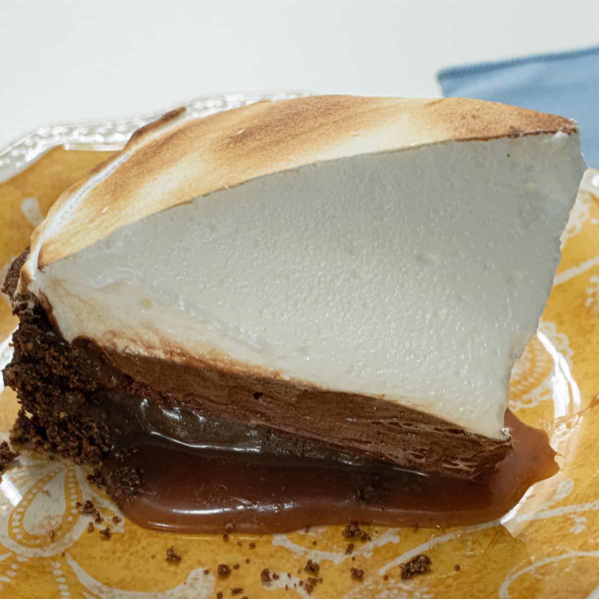 A slice of Sky High Chocolate Pies sits on an orange and white plate.